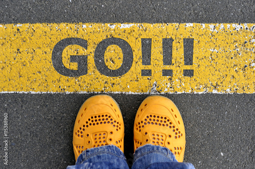 Top View of yellow shoes on the asphalt road with yellow line. G