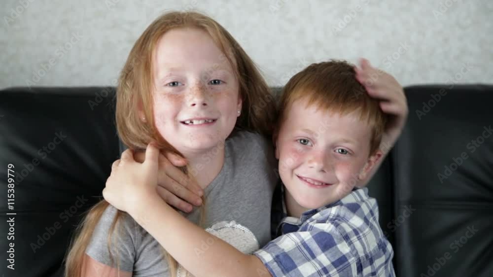 Brother and sister are fooling and playing on the sofa in the room Brother and sister are fooling and playing on the sofa in the room
