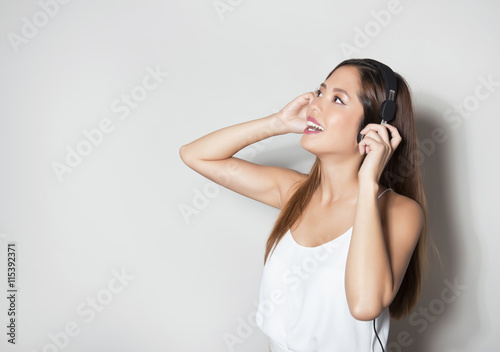 beautiful young asian woman listening to music with headphones