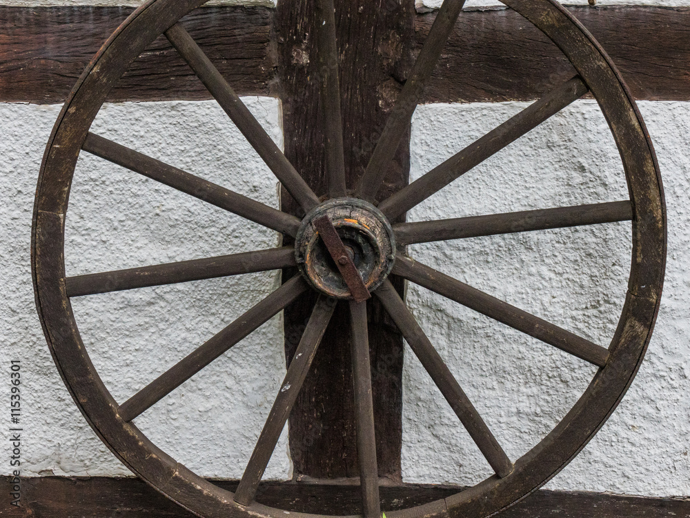The old  wheel on wall of  farmhouse