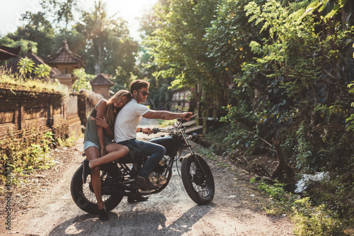 Young man and woman on motorbike in a village