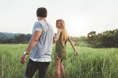 Young couple enjoying a walk through grassland