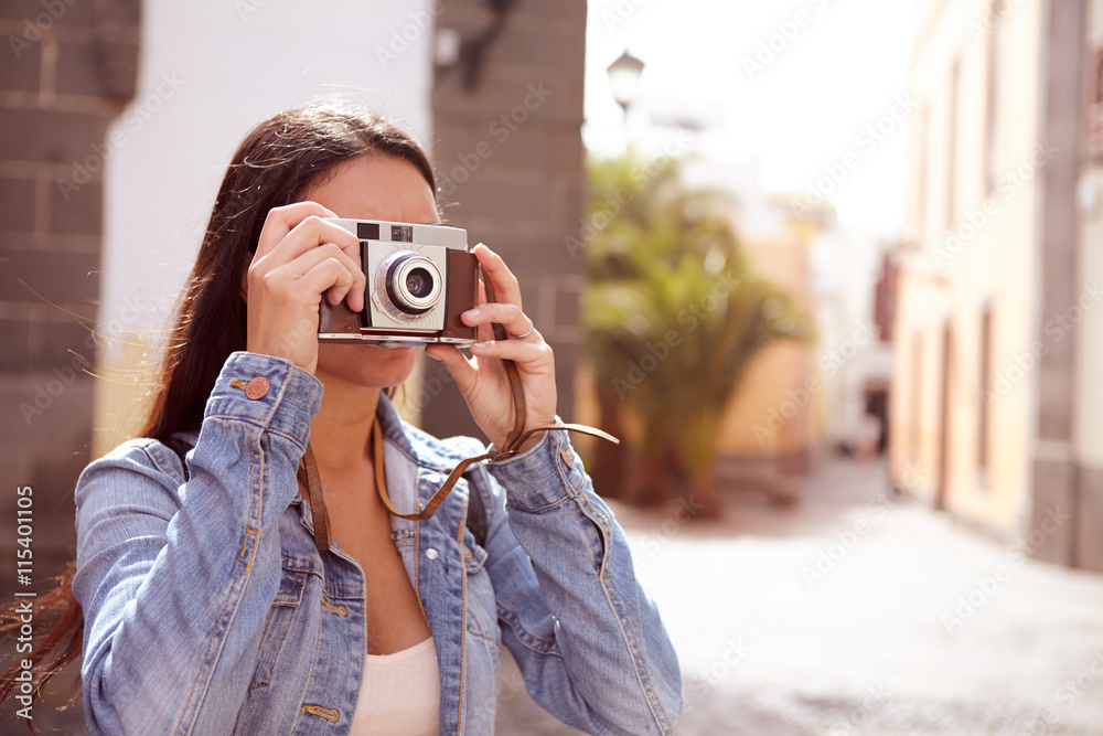 Young brunette focusing her old camera