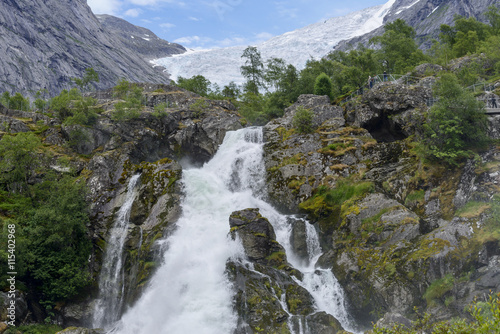 Briksdalsbreen glacier at summer with waterfall from melted ice on foreground. Jostedalsbreen National Park in Norway.