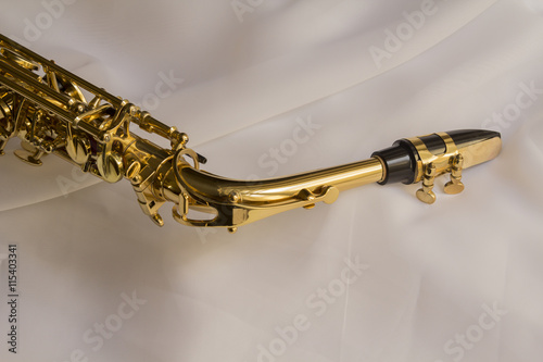 beautiful golden saxophone on delicate White silk background