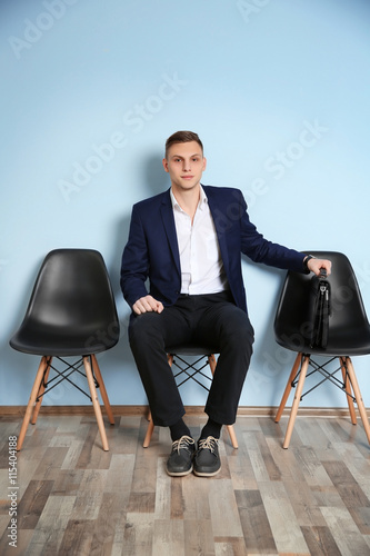 Young man in suit sitting o...