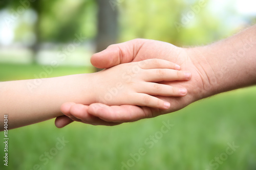 Adult and child hands on natural background © Africa Studio