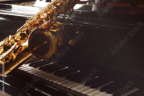 Canvas Print Saxophone lying on the piano, close up