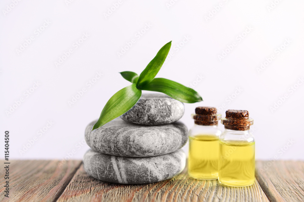 Gray spa stones with oil on light background Gray spa stones with oil on light background
