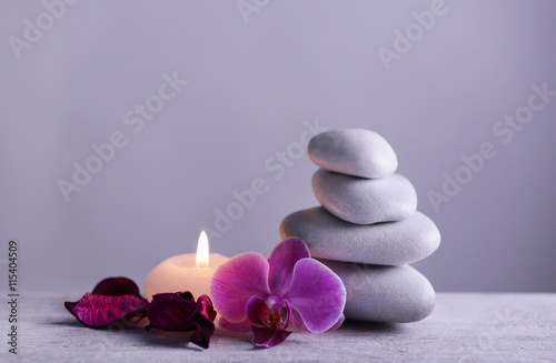 White spa stones with candle on gray background