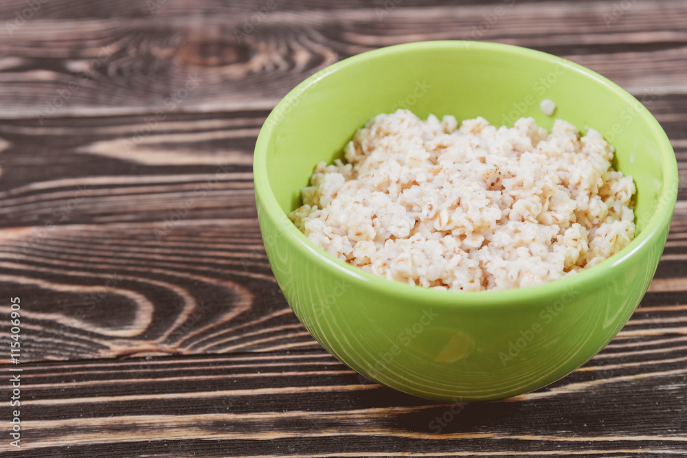 Oatmeal in Green Bowl on Wooden Table