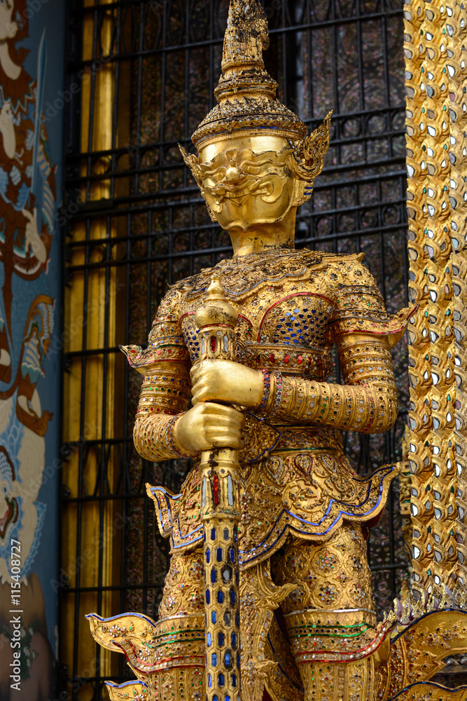 Gold yaksha demon at entrance to Phra Mondop library at historic Grand Palace in Bangkok, Thailand