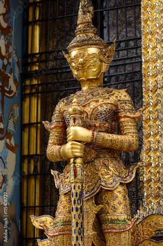 Gold yaksha demon at entrance to Phra Mondop library at historic Grand Palace in Bangkok, Thailand