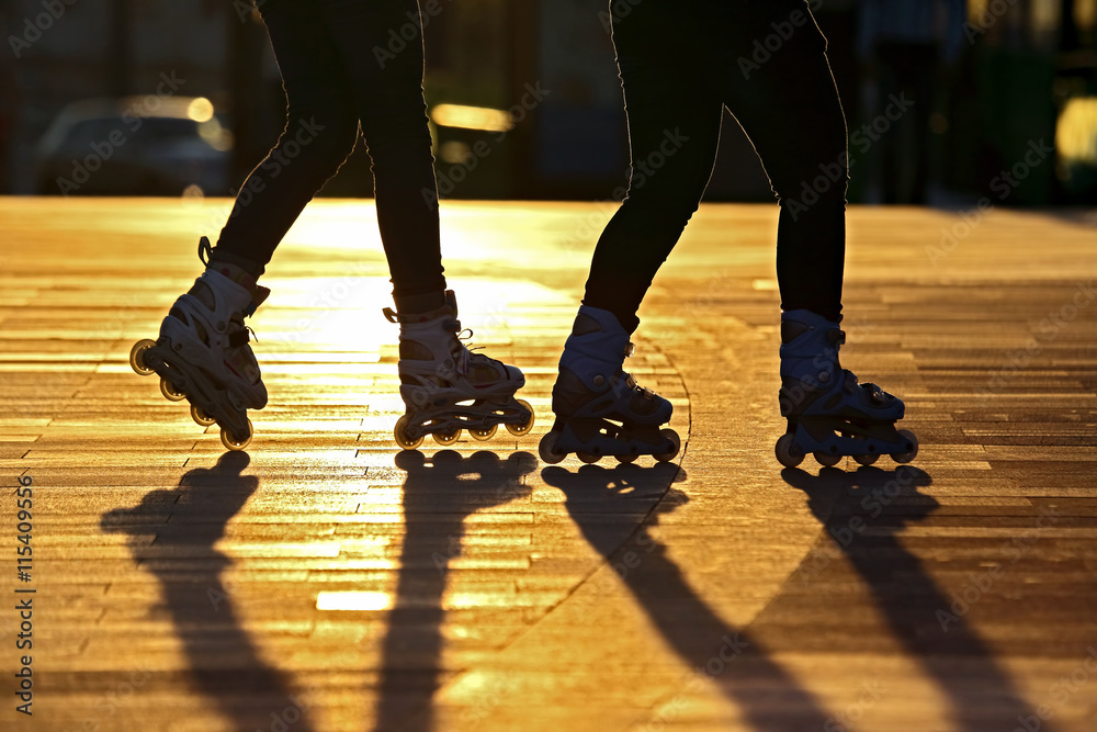 Obraz premium silhouette of two pairs of legs on roller skates