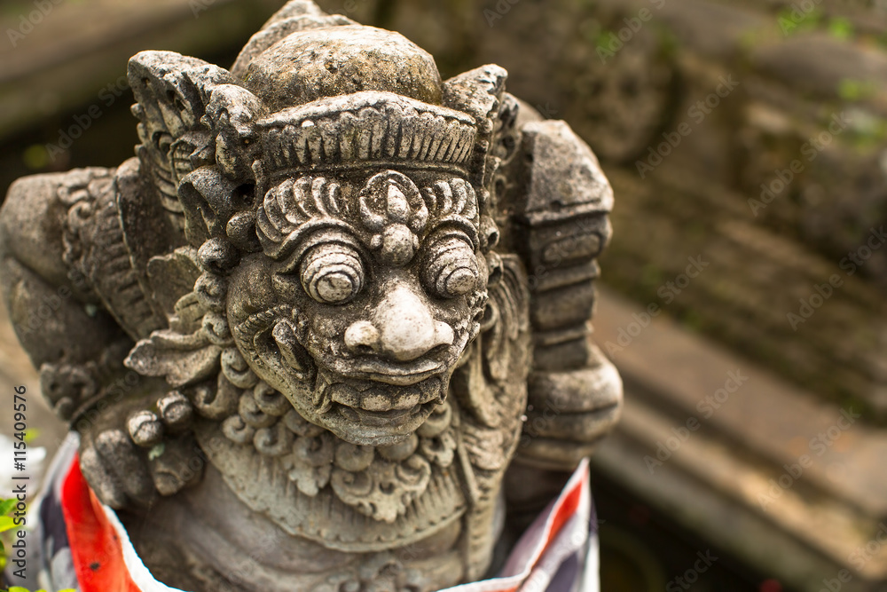Traditional demon guard statue carved in stone, Bali island, Indonesia.