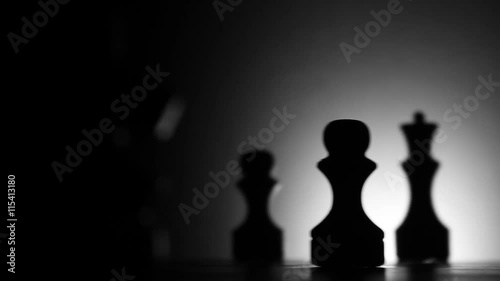 Chessboard and chess pieces in dark room