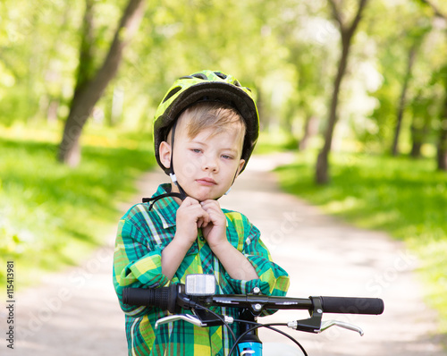 little boy wears a bicycle helmet