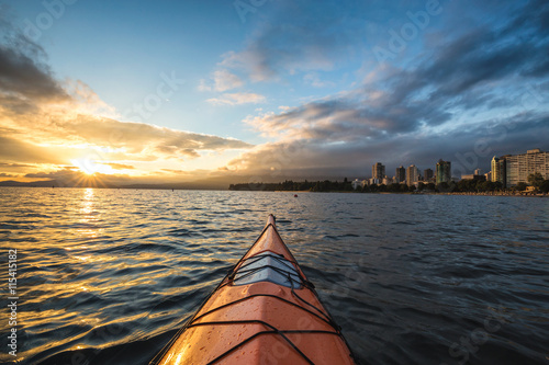 Kayaking near English Bay in Downtown Vancouver, BC, Canada, during a beautiful cloudy sunset.