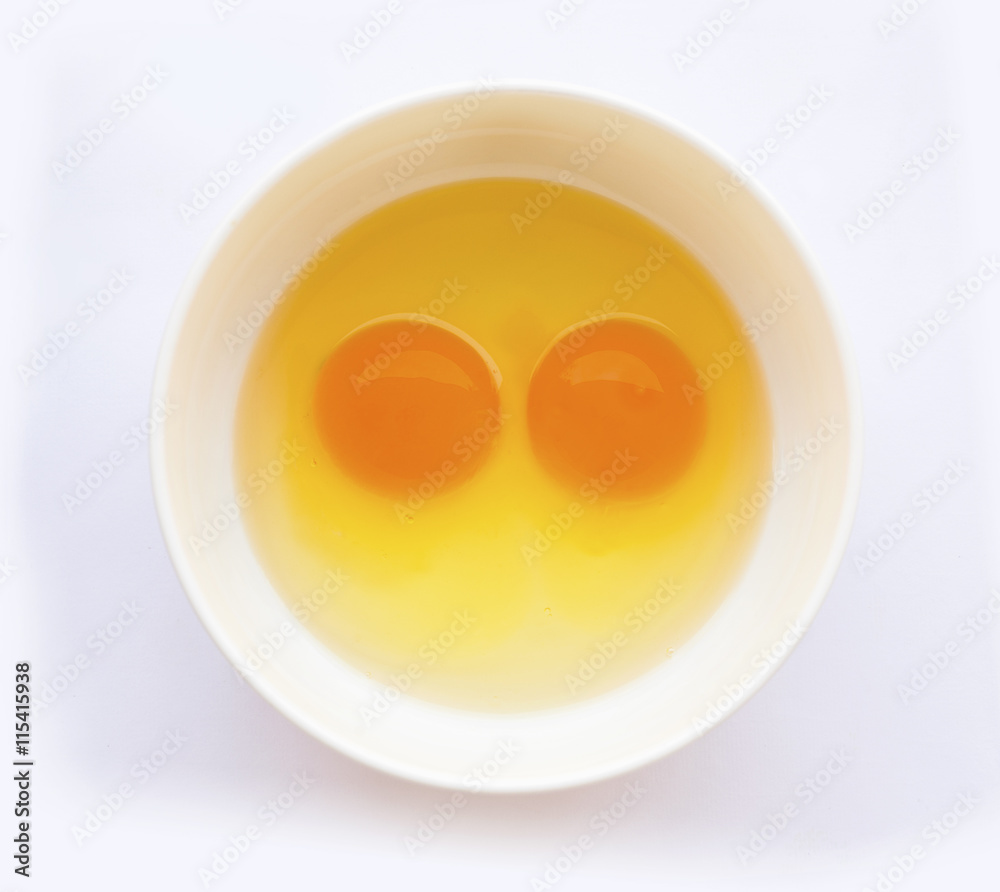 Egg yoks un-cooked in white bowl, solid white background Egg yoks un-cooked in white bowl, solid white background