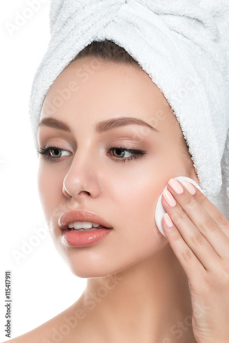 Portrait of young beautiful woman cleaning her face