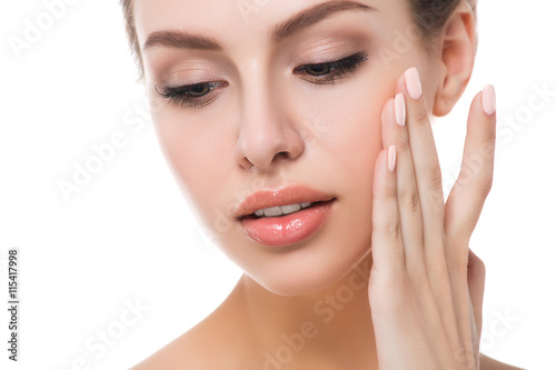 Portrait of young beautiful woman touching her face