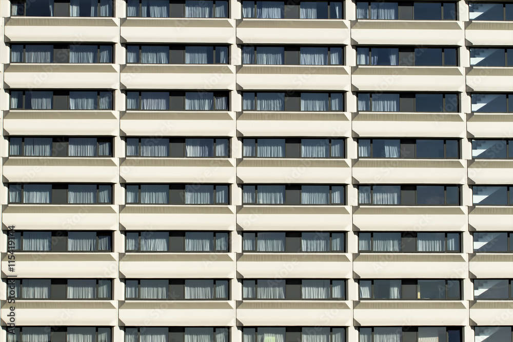 Modern building front wall with repeating pattern of windows. Close up. Background Modern building front wall with repeating pattern of windows. Close up. Background