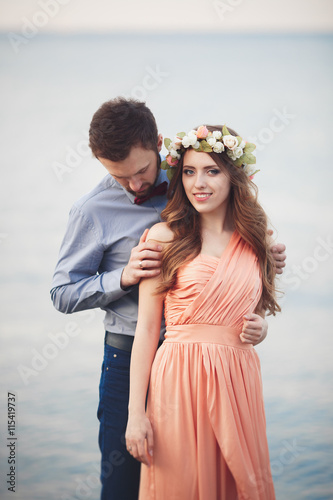 Married wedding couple standing on a wharf over the sea