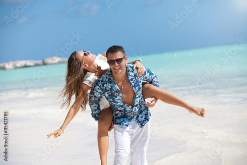 Beach couple having fun laughing on Caribbean holidays.