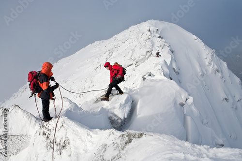 Climbing in mountains. Team work.