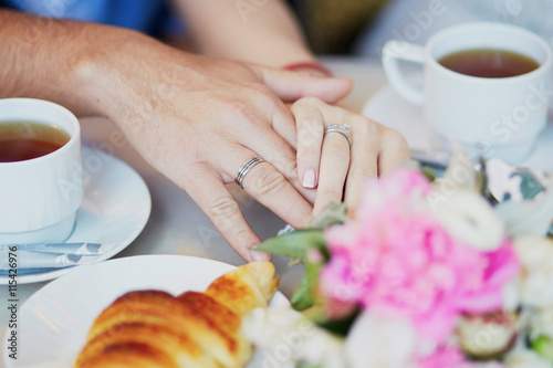 Just married couple holding hands in Parisian cafe photo