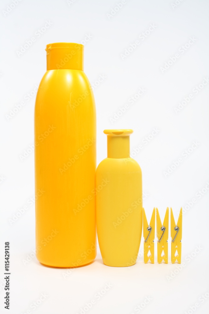 Yellow plastic jars and clothespins on a white background Yellow plastic jars and clothespins on a white background