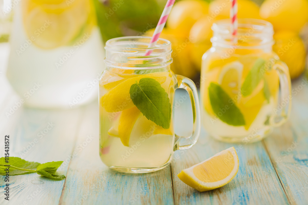 lemonade with mint on rocks served in jar with a straw lemonade with mint on rocks served in jar with a straw