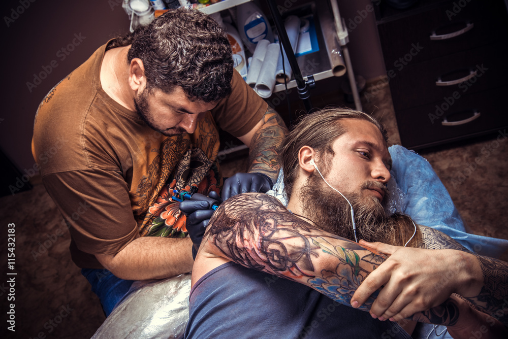 Fototapeta premium Professional tattooist at work in tattoo studio