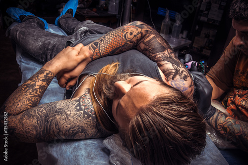 Fotografie Tattooer makes tattoo pictures in tattoo studio