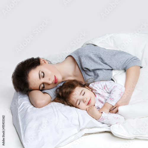 Beautiful mother and daughter in bed