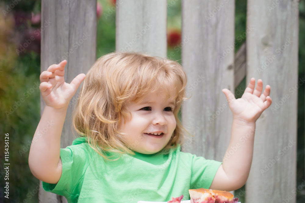 small boy eating pie near wooden fence small boy eating pie near wooden fence