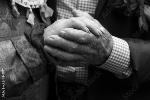Elderly man and an elderly woman holding hands.Black and white