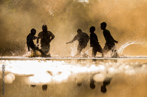 Boys playfully splashing water on each other on holiday.