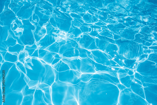 Blue water surface with sun reflection in swimming pool