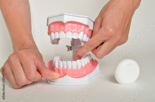 Showing how to use floss, dental care concept