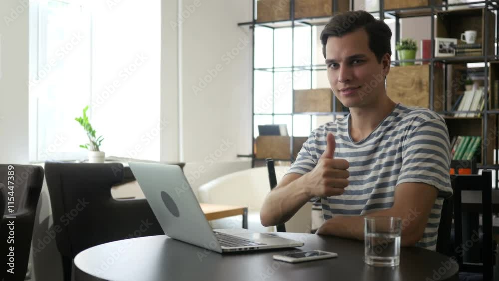 Cheerful office worker at desk doing thumb up sign and smiling. Real workplace Cheerful office worker at desk doing thumb up sign and smiling. Real workplace