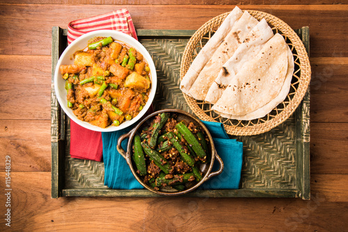 bhindi masala or bhendi masala or ladies finger fry with mixed veg in red curry with indian roti / chapati / fulka / paratha / indian bread, indian spicy food photo