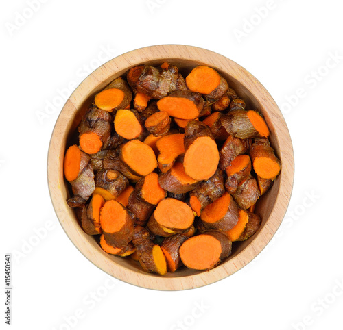 Top view sliced turmeric in wood bowl on white background photo
