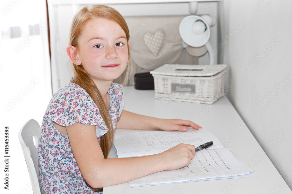 Cute little girl studying at home and smiling Cute little girl studying at home and smiling