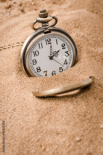 Vintage necklace watch on the sand beach