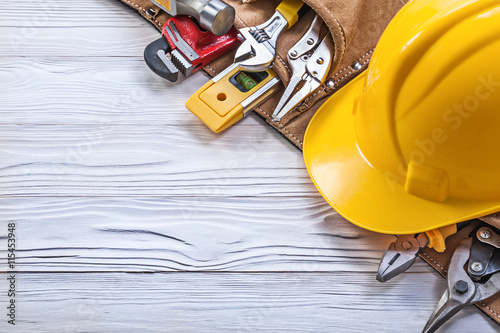 Construction belt hard hat on wooden board maintenance concept