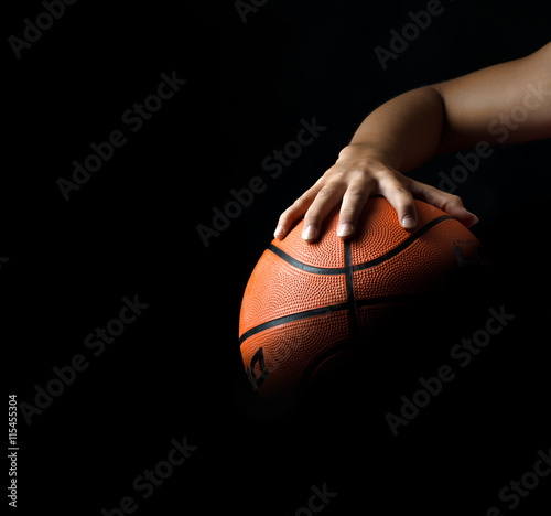 fragment of a basketball ball in a hand of the basketball player © kulichok