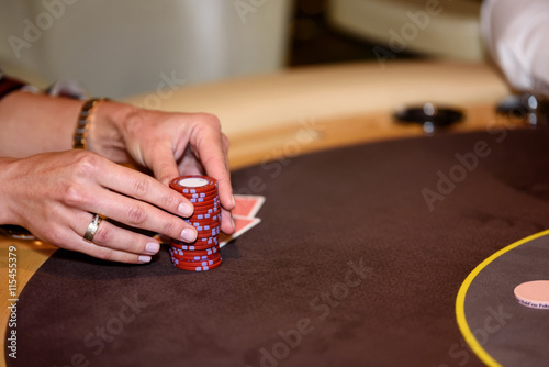 Closeup of hands with chips on poker table, selective focus