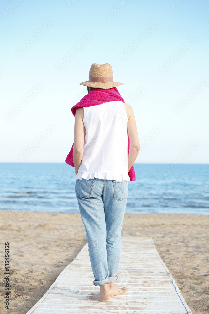 Starting her vacation on the seaside. Mature woman walking on the beach. Starting her vacation on the seaside. Mature woman walking on the beach.