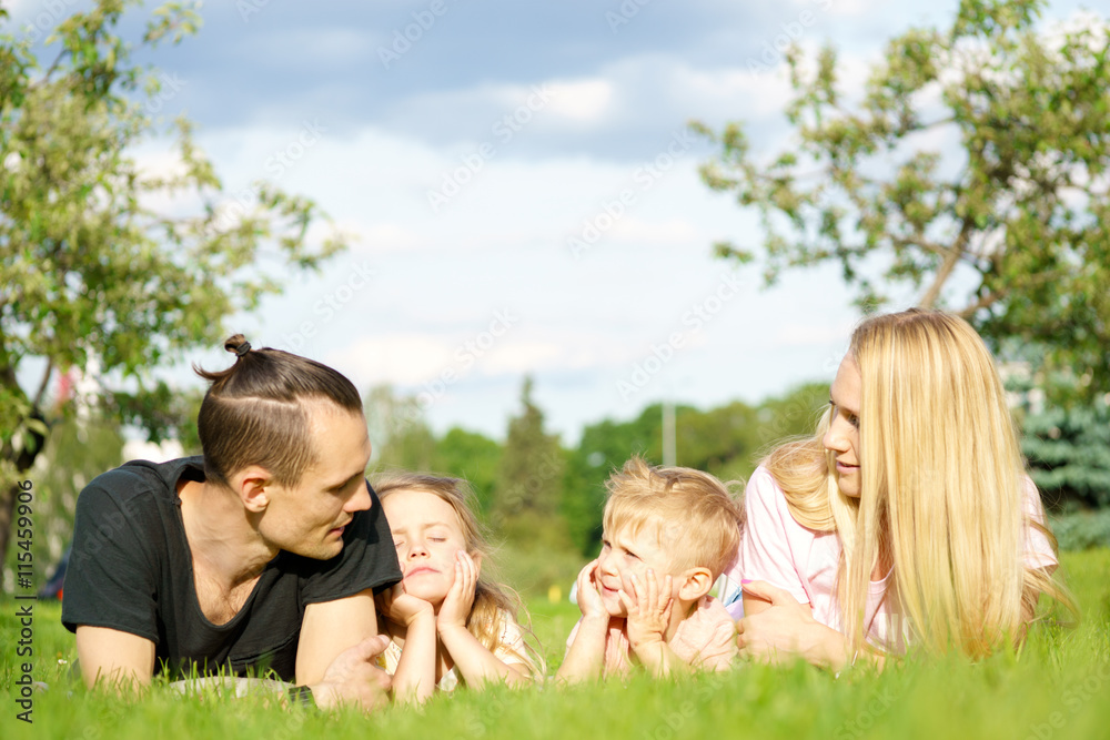 Portrait of happy parents with kids lying at the park Portrait of happy parents with kids lying at the park